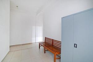 een houten bank in een kamer met een muur bij Hotel O Sepakat Guest House in Medan