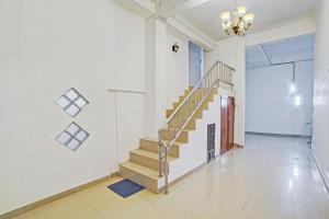 een hal met een trap in een huis bij Hotel O Sepakat Guest House in Medan