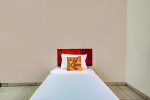 a bed with a orange and yellow pillow on it at Hotel O Al-ghani 2 Syariah in Padang +21 photos