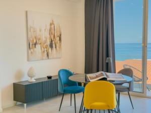 ein Esszimmer mit Tisch und Stühlen und einem Fenster in der Unterkunft Casa A'mar in Giardini-Naxos