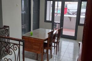 Un comedor con mesa y sillas de madera. en Hotel O Gardenia Boarding House, en Purwokerto