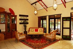a living room with a couch and chairs and a table at Hotel O Cemara's Homestay in Batu