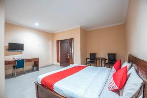 a bedroom with a bed and a desk and chairs at Hotel O Bunga Karang Hotel in Bekasi