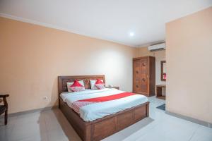 a bedroom with a bed with red and white pillows at Hotel O Bunga Karang Hotel in Bekasi