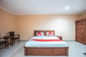 a bedroom with a bed with red pillows on it at Hotel O Bunga Karang Hotel in Bekasi
