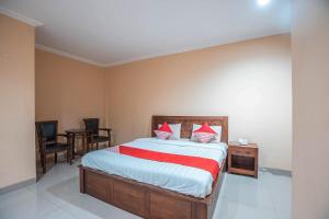 a bedroom with a bed and a table and chairs at Hotel O Bunga Karang Hotel in Bekasi +33 photos