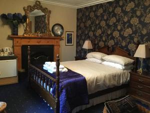 a bedroom with a bed with a fireplace and a mirror at Dionard Guest House in Inverness