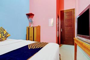 a bedroom with a bed and a flat screen tv at OYO 90268 Aliyah Syariah in Jakarta