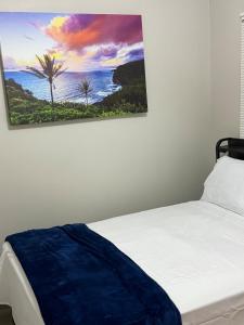 a bedroom with a bed with a painting on the wall at The Family Retreat in Calumet City