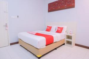 een slaapkamer met een groot bed met rode kussens bij Capital O 2018 Ring Road Guest House Syariah in Banda Aceh