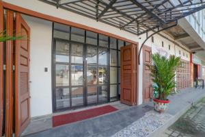 an entrance to a building with glass doors and plants at Capital O 90447 Kardopa Hotel Megapark in Medan