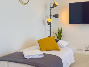 ein Schlafzimmer mit einem Bett mit gelbem Kissen und einer Lampe in der Unterkunft Casa A'mar in Giardini-Naxos