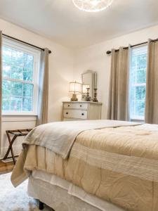 a bedroom with a large bed and two windows at Cozy 2BR Apt w KING in historic dist. 1mi to sq. in Columbia +39 photos