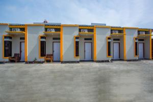 a yellow and white building with doors and windows at Hotel O Griya Annisa in Tegal