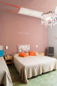 um quarto com uma cama com almofadas laranja e um lustre em Hotel Panorama em Florença