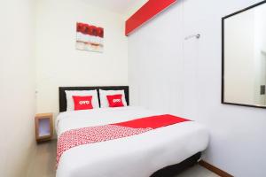 a bedroom with a white bed with red pillows at Flagship 3688 Pot Art in Surabaya