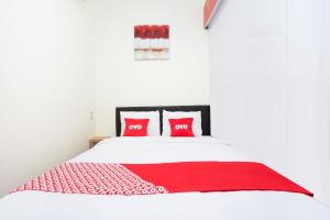a bedroom with a white bed with red pillows at Flagship 3688 Pot Art in Surabaya