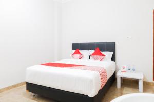 a bedroom with a large bed with red and white pillows at Hotel O Axl Residence in Jakarta +21 photos