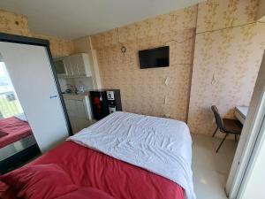 Un pequeño dormitorio con una cama y una cocina. en OYO Life 93106 Apartement Grand Sentraland By Andi, en Karawang 23 fotos más