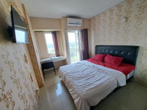 Un dormitorio con una cama con almohadas rojas. en OYO Life 93106 Apartement Grand Sentraland By Andi, en Karawang