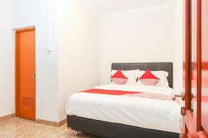 a bedroom with a bed with red pillows on it at Hotel O Axl Residence in Jakarta