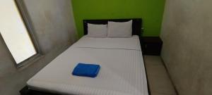 a bed in a room with a blue object on it at Hotel O Azwa Gh Katingan Near Lapangan Sepak Bola Pegatan Hilir in Pagatan