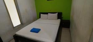 a small bed with a blue box on it at Hotel O Azwa Gh Katingan Near Lapangan Sepak Bola Pegatan Hilir in Pagatan