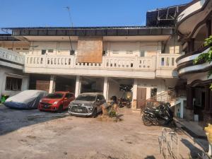 eine Gruppe von Autos, die auf einem Parkplatz vor einem Gebäude geparkt sind in der Unterkunft OYO Life 93160 Kost Jenny Karawang in Karawang