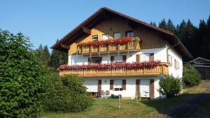 a building with a balcony with red flowers on it at Haus Bergblick in Lindberg