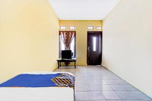 ein Schlafzimmer mit einem Bett, einer Tür und einem TV in der Unterkunft OYO Life 90701 Kost Syariah Deris in Sumedang