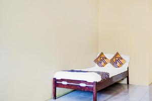 ein kleines Bett mit zwei Kissen darauf in einem Zimmer in der Unterkunft OYO Life 90701 Kost Syariah Deris in Sumedang