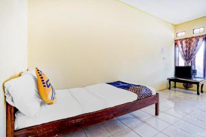 ein Schlafzimmer mit einem Bett und einem Kissen darauf in der Unterkunft OYO Life 90701 Kost Syariah Deris in Sumedang