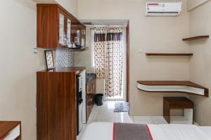 a small room with a bed and a kitchen at Capital O 93371 Pelangi Residence 5 in Tangerang