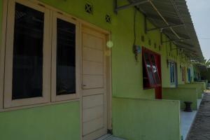a green building with a door on the side of it at OYO Life 93382 Gajayana Kost Female Only Syariah in Jenggrik