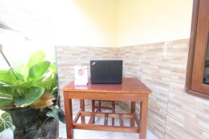 a small wooden table with a laptop computer on it at OYO Life 93403 Penginapan Adinda in Tjakranegara