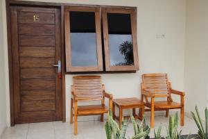 two chairs and a door with two windows at Hotel O Lembah Sriti Homestay Near Sirkuit Motor Cross Internasional 459 Lantan in Labuan Lombok