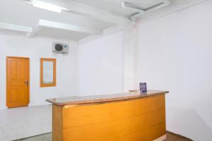 a wooden counter in a white room with a door at OYO Life 2412 Mandala Residence in Pundong