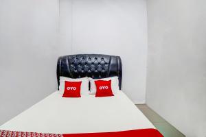 two red pillows on a bed in a room at Hotel O near Citraland formerly Brayan Guest House in Medan