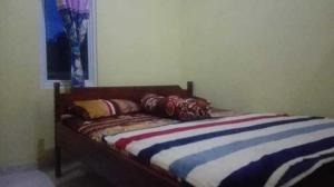 a bed with pillows on it in a room at Hotel O Wisma Nadira Near SPBU PT. Trijaya Pugung PENENGAHAN in Karbang