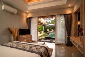una camera con letto e vista sulla piscina di The Macaw Ubud Green Uma Villa a Blahbatu