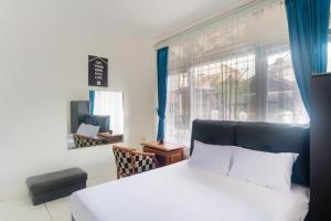 Un dormitorio con una cama blanca y una ventana. en OYO Life 3055 Rumah Enin, en Bandung 22 fotos más