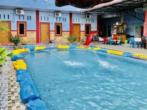 einem Pool mit Wasserrutsche in einem Gebäude in der Unterkunft OYO 3334 Ratu Residence in Medan