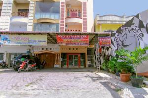 ein Gebäude mit einem davor geparkten Motorrad in der Unterkunft OYO 3334 Ratu Residence in Medan + 33 Fotos