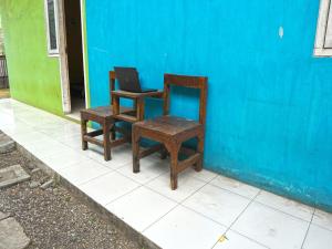 a pair of chairs and a chair with a mirror at Hotel O Rumah Kos Arafah Syariah in Probolinggo