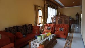 un salon avec un canapé et deux chaises dans l'établissement OYO Life 92886 Rumah Nyaman Radhika 2 Syariah, à Tuban
