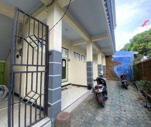 two motorcycles parked outside of a building with a gate at OYO Life 93401 Kos Putri Alamanda Syariah in Tjakranegara