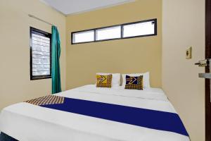 a bedroom with a bed with two pillows and a window at OYO Life 91116 Pelangi Residence Syariah in Jatiroke