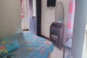 a bedroom with a bed and a mirror and a dresser at Hotel O Aida Lestari in Sebulu