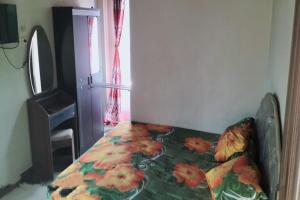 a bed in a room with a flower blanket on it at Hotel O Aida Lestari in Sebulu