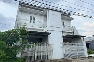 a white house with a white fence in front of it at Hotel O Kost Aisyah Near Citra Grand Galesong City(Pattalassang) in Bilibili